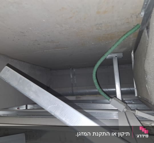 תעלת מיזוג אוויר עם צינור ירוק ומבנה מתכת